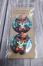 Car coasters with skull design in colorful hats and bow ties, packaged on a wooden surface.