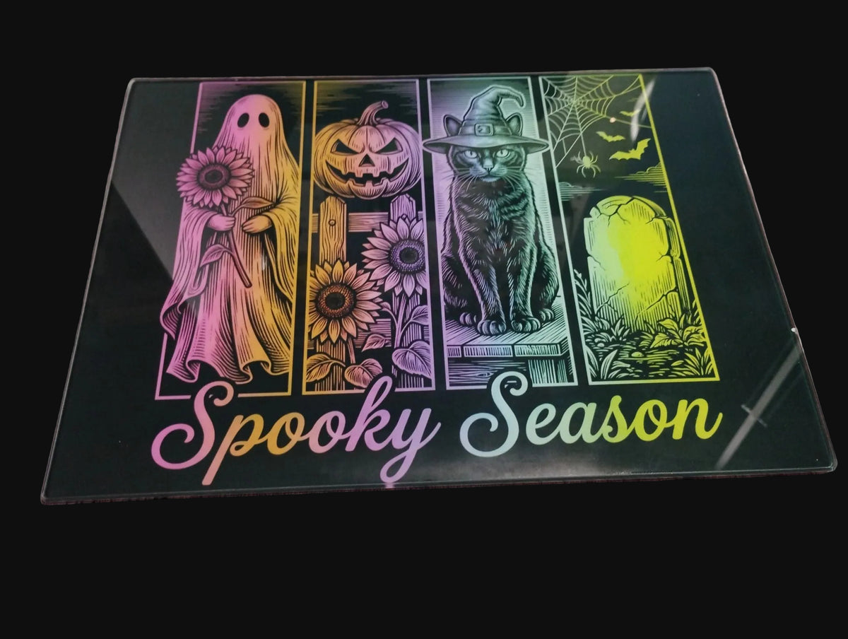 Spooky Season Glass Chopping Board featuring ghost, jack-o-lantern, black cat and graveyard neon design
