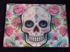 Colorful skull design with pink roses on a black background