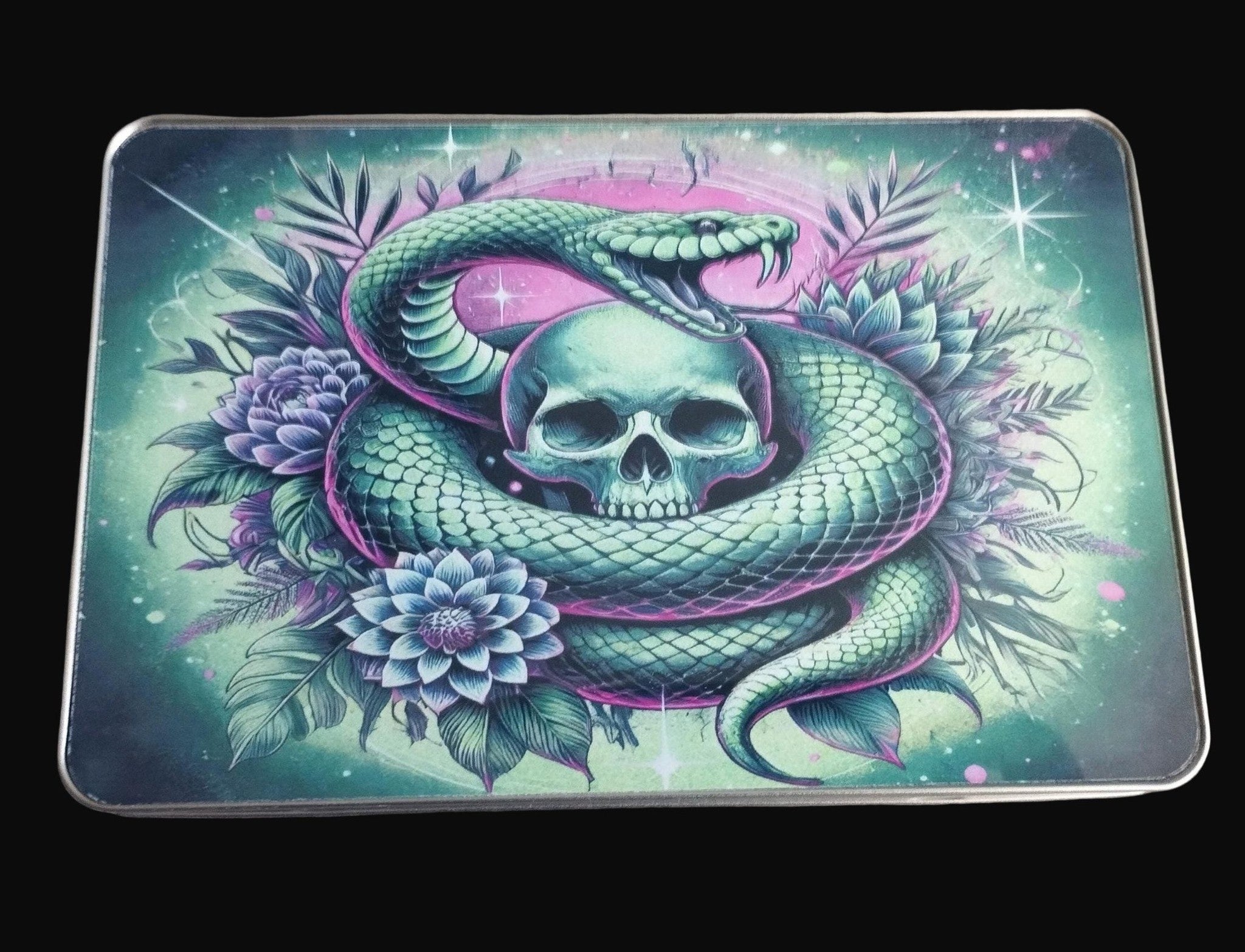 Decorative tray with a snake and skull design on a wooden surface