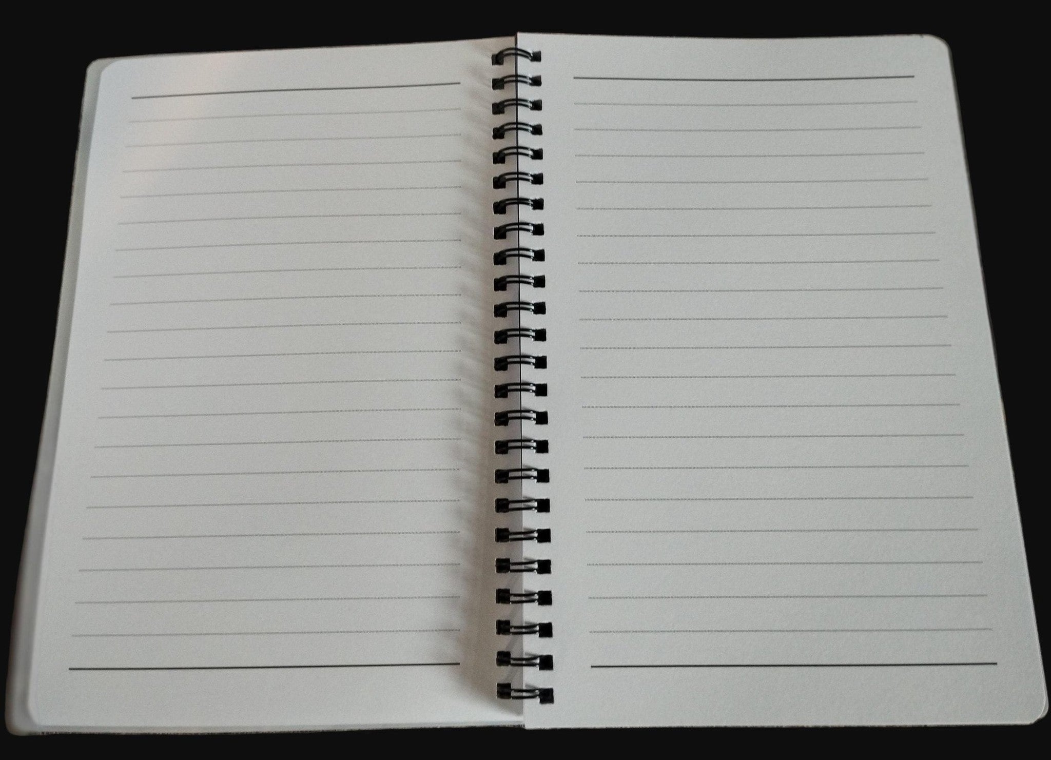 Open notebook with lined pages on a wooden surface