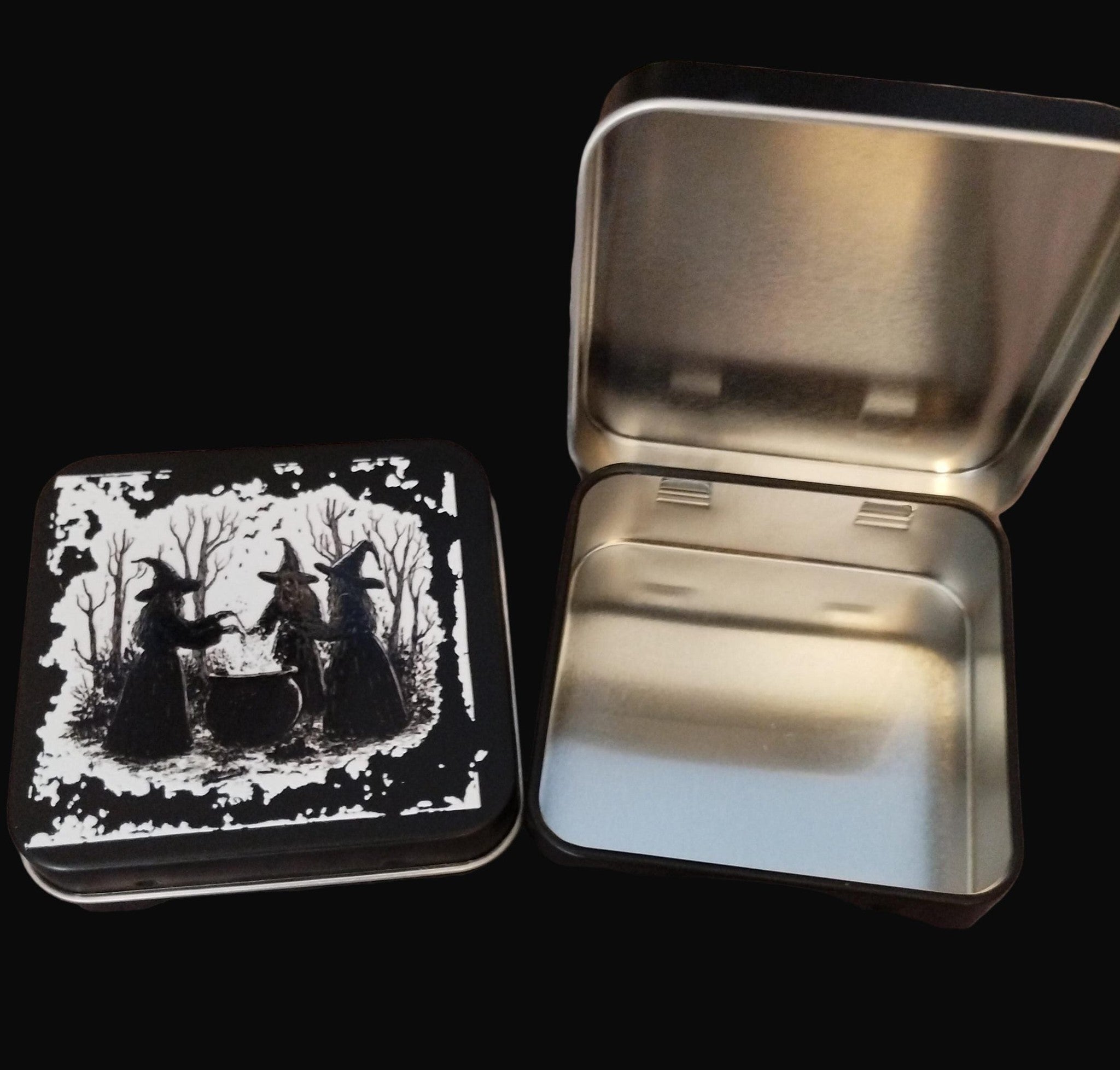 Metallic tin with a black and white witch design on a wooden surface