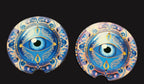 Two decorative coasters with eye design on a wooden surface