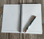 Open notebook with a pen on a wooden surface