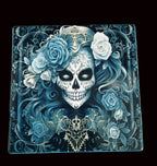 Decorative tile with a skull and floral design on a wooden surface