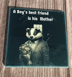 Coaster with a badger holding flowers and text 'A Boy's best friend is his Mother' on a wooden surface