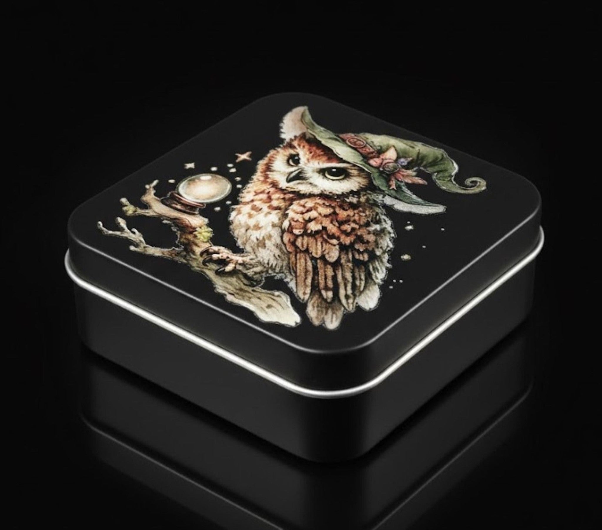 Black tin box with an owl illustration on a black background