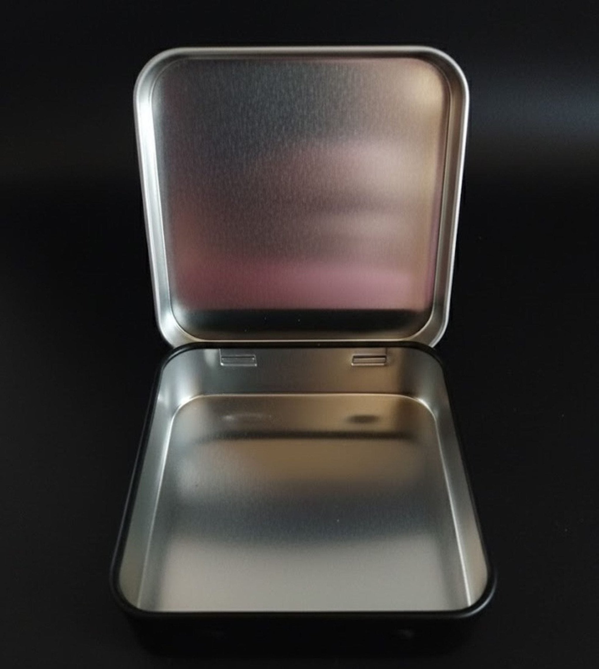 Metallic rectangular box with a lid on a black background