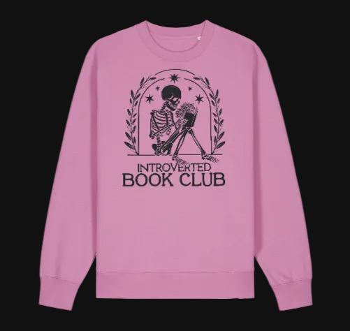 Pink sweatshirt with skeleton and book design labeled 'Introverted Book Club' on a white background