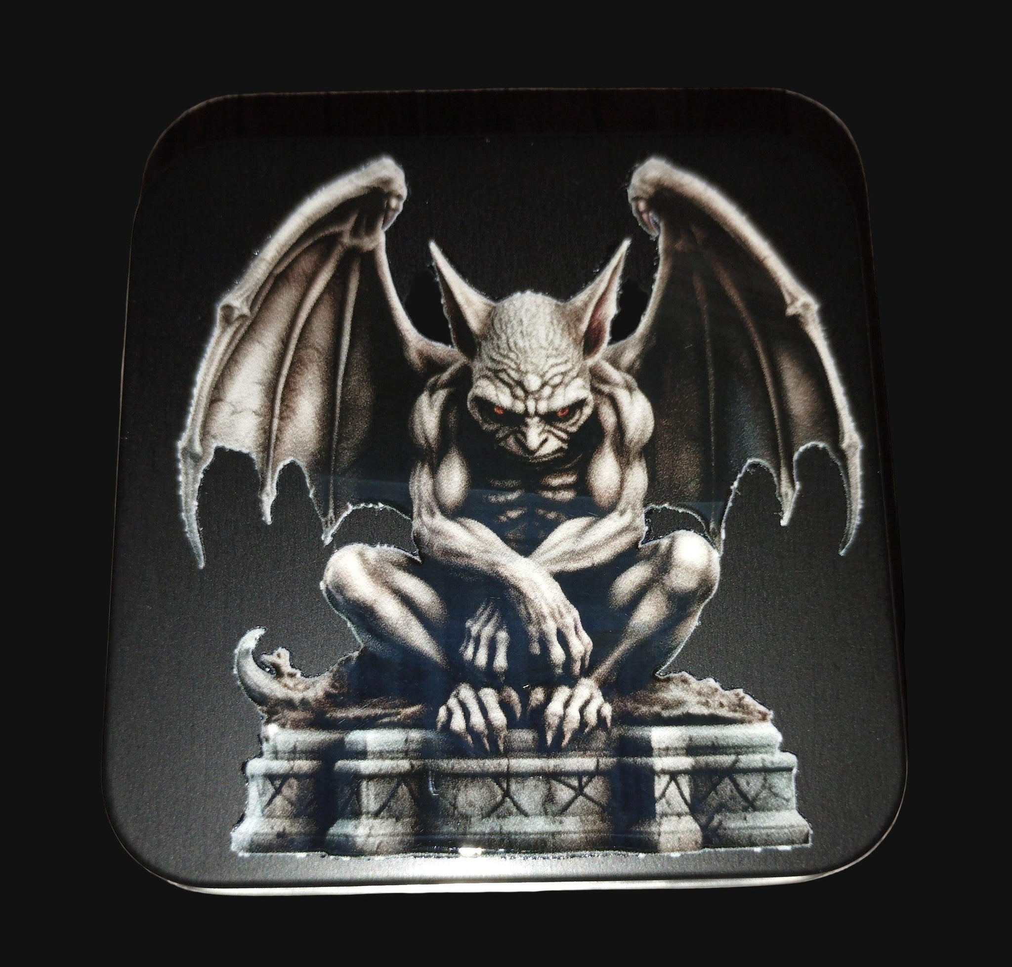Gargoyle design on a small Black tin