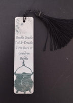Bookmark with cauldron design and text on a dark background