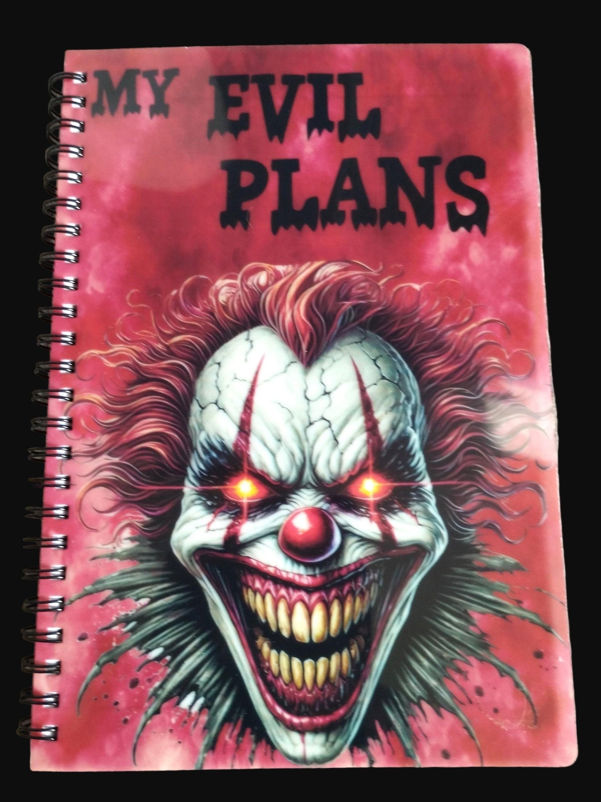 Notebook with a clown design and 'My Evil Plans' text on a wooden surface