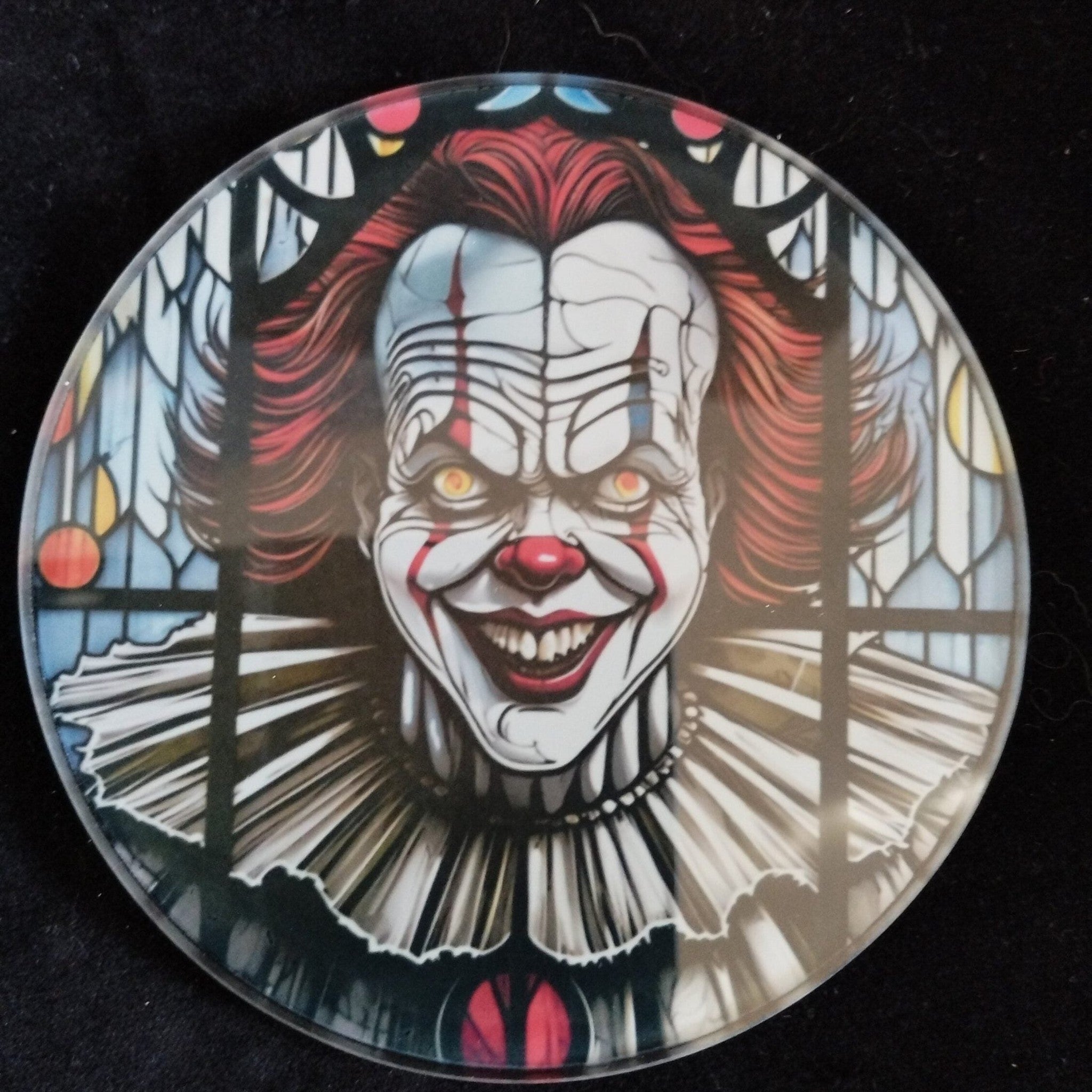 Circular coaster with a clown design on a black background