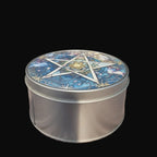 Metal tin with a decorative lid featuring a star design on a wooden surface.