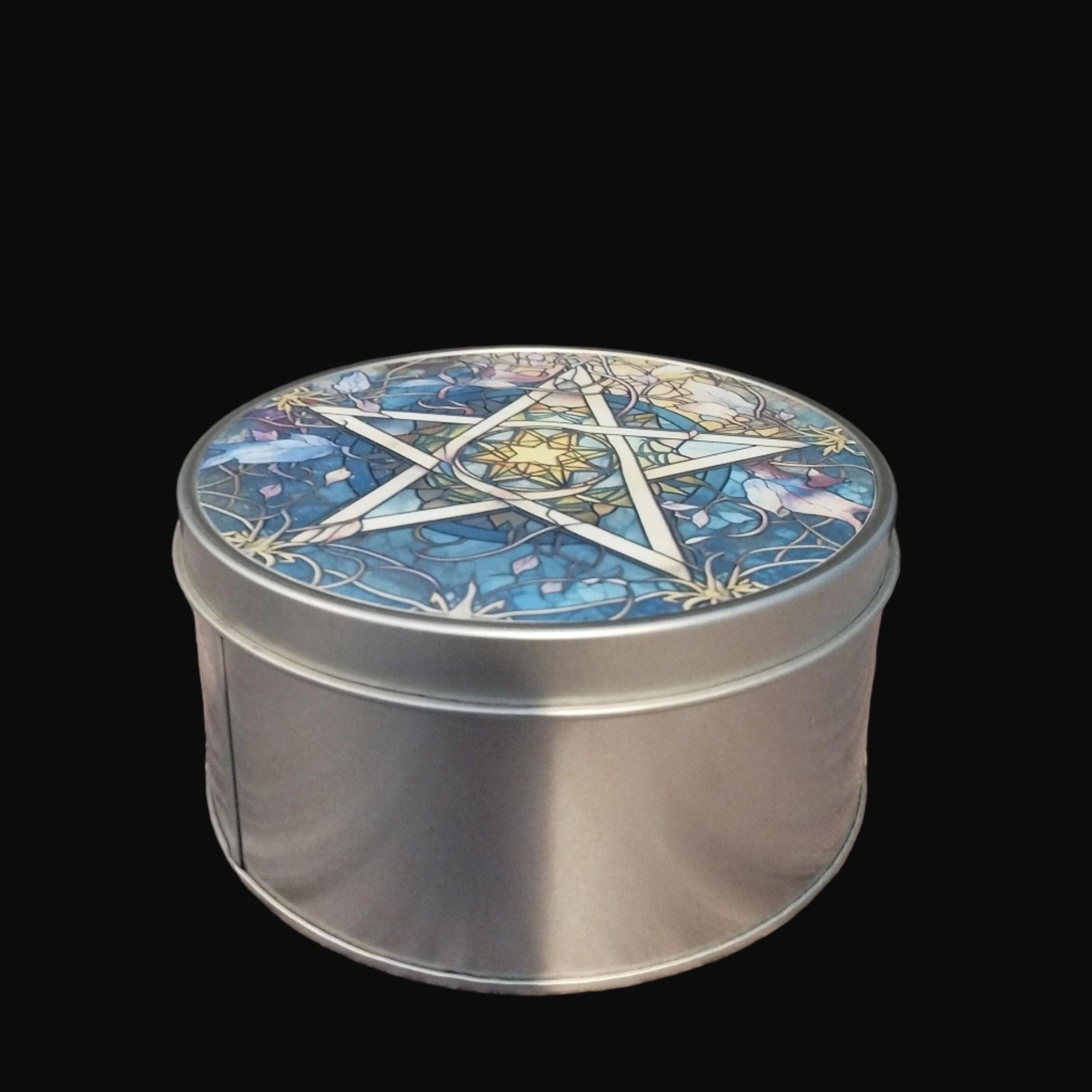 Metal tin with a decorative lid featuring a star design on a wooden surface.