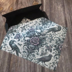 Decorative lens cloth with skull and rose design on a wooden surface