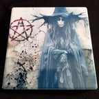 Decorative coaster with a witch design and pentagram symbol on a black background