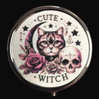 Compact mirror with a cat, skull, and floral design on a wooden surface