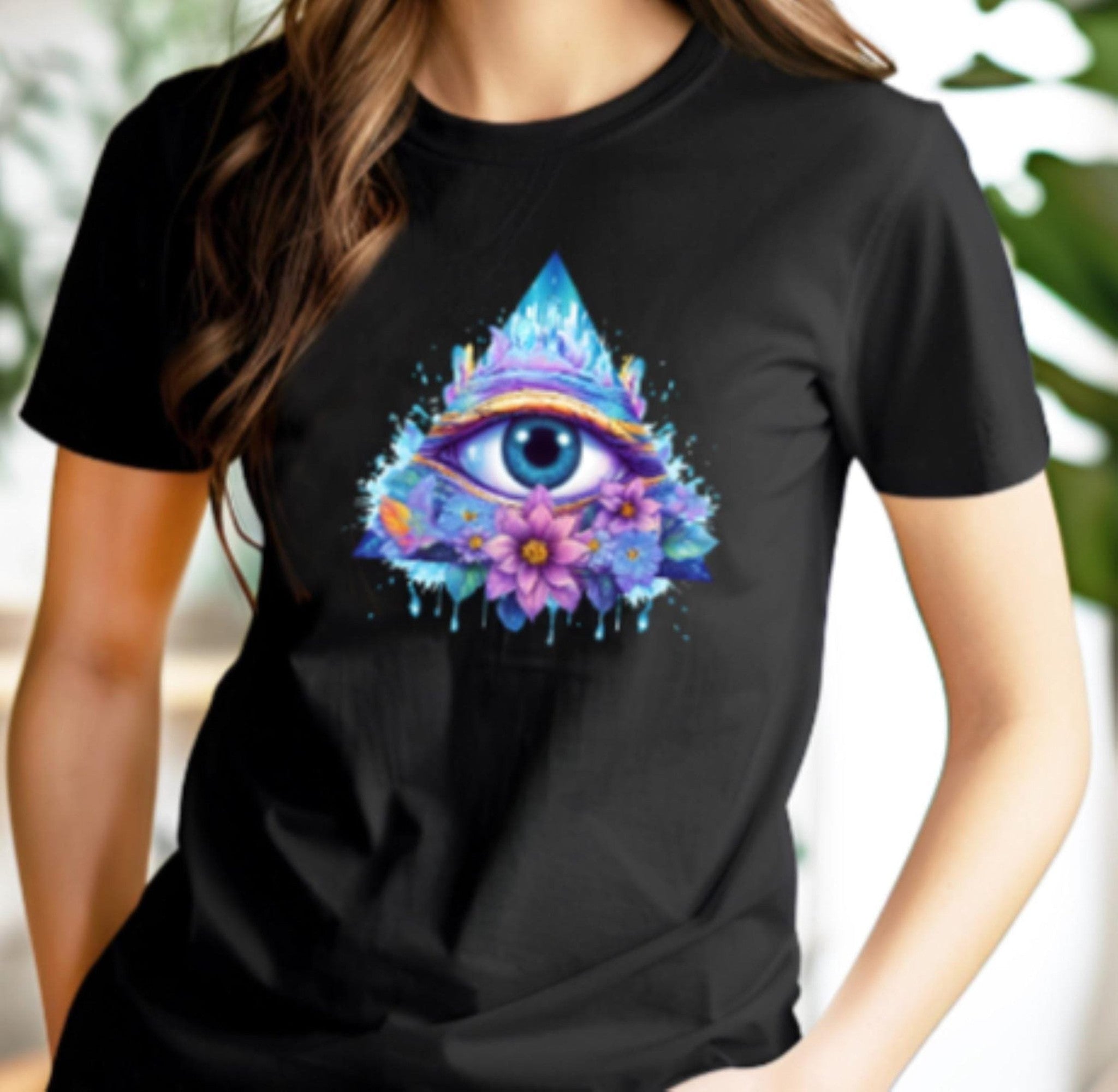 Black t-shirt with a colorful eye and floral design worn by a person.