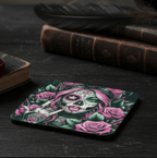 Coaster with a skull and floral design on a dark surface with books and feathers.