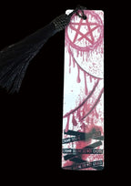 Bookmark with a black tassel on a wooden surface, featuring a design with red and black text.