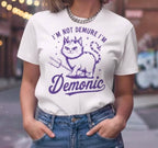 Person wearing a white t-shirt with a cat graphic and text in an urban setting