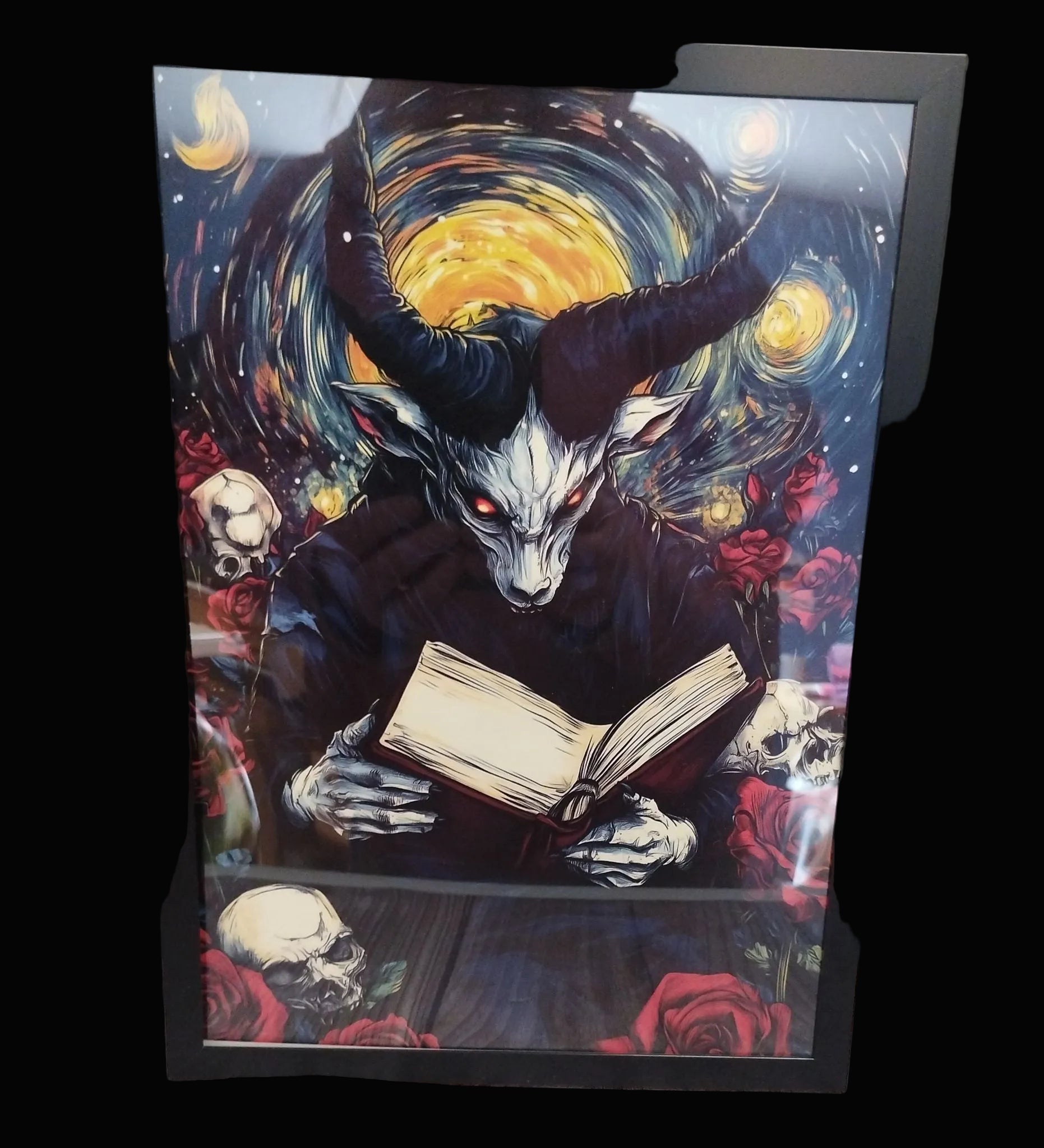 Framed artwork of a creature with horns reading a book against a starry night sky.