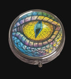 Pill tin with colourful  dragon eye design on a wooden surface