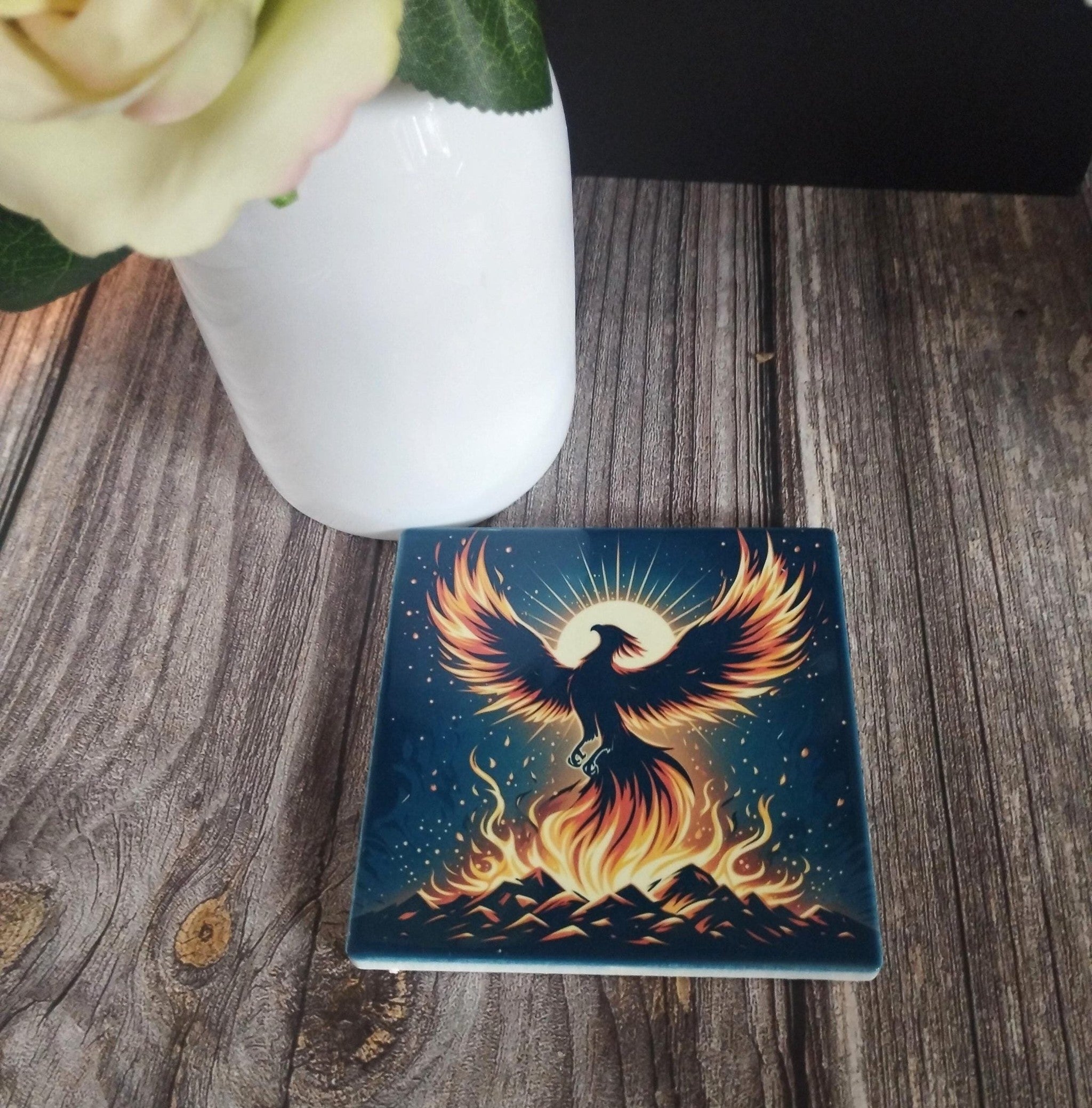 Decorative coaster with a phoenix design on a wooden surface