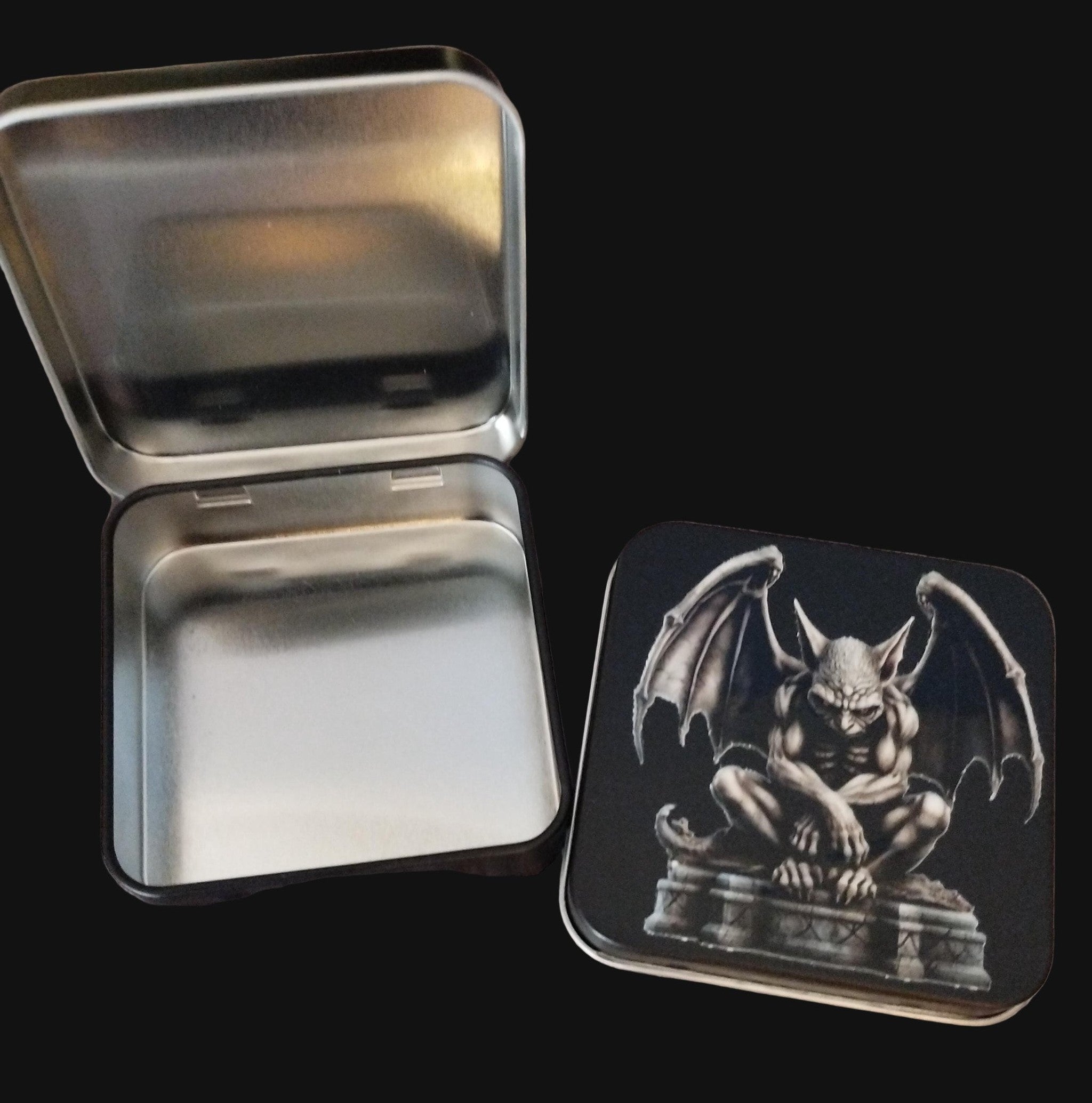 Metallic tin with a gargoyle design on a black surface