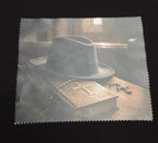 Gothic lens cloth with zigzag edges featuring a black hat, an aged book and crosses in a shadowy scene