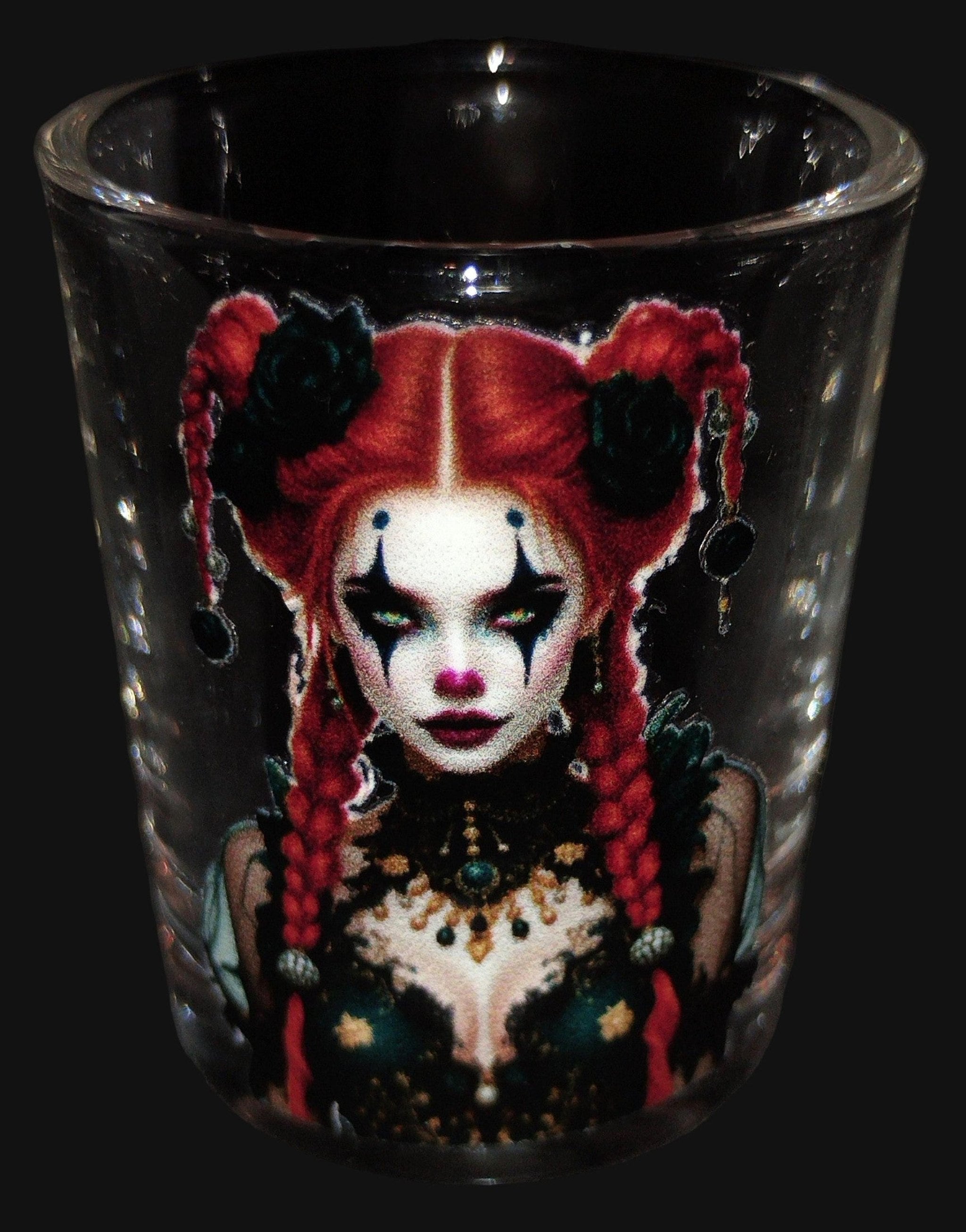 Black shot glass with a colorful design of a woman with red hair and black eyes on a dark background
