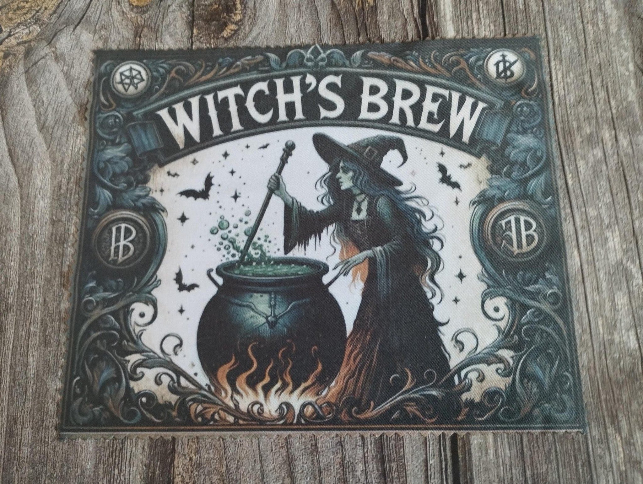 Decorative sign with a witch and pot of brew on a wooden surface