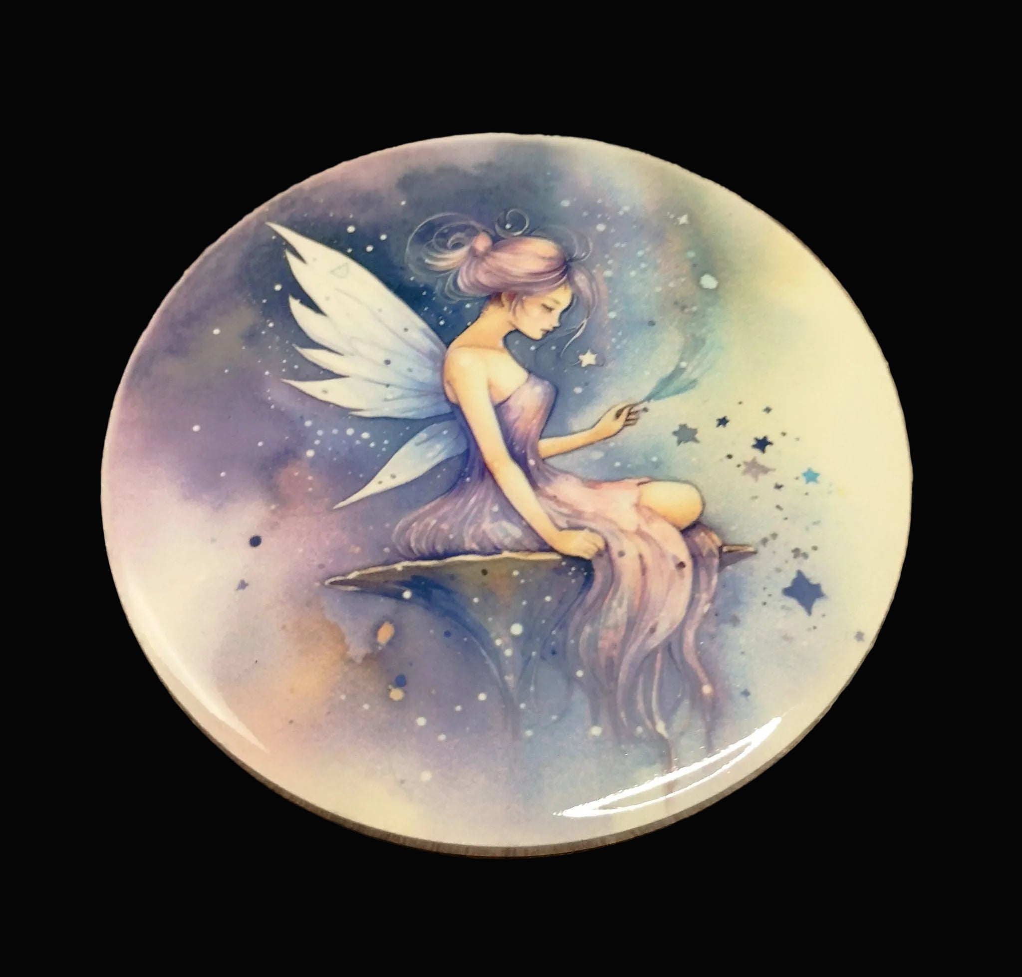 Round ceramic fairy coaster featuring a fairy sitting on a mushroom surrounded by stars, on a wooden background