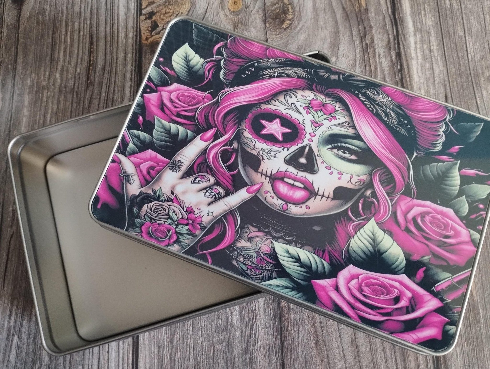 Laptop with a colorful skull and rose design on a wooden surface