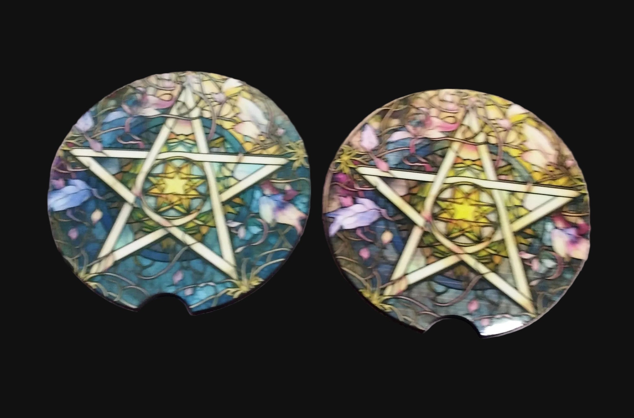 Two car coasters with pentagram designs on a wooden surface