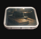 Silver-coloured rectangular tobacco tin with dark artwork showing a black hat on an aged book with cross and rosary-style details.