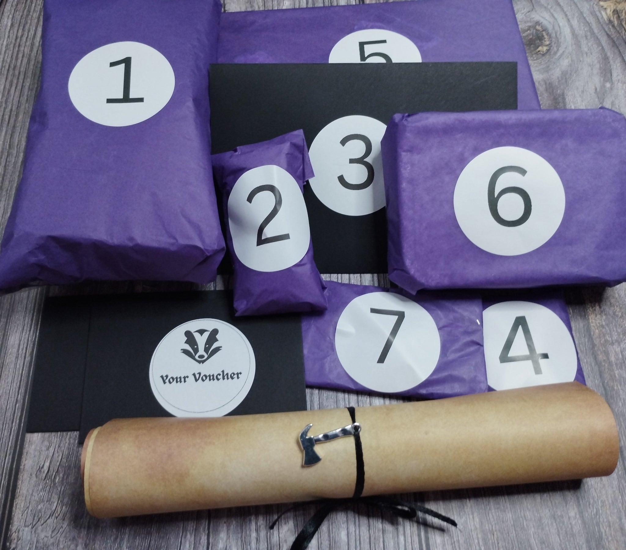 Purple envelopes with numbers and a rolled-up paper voucher on a wooden surface